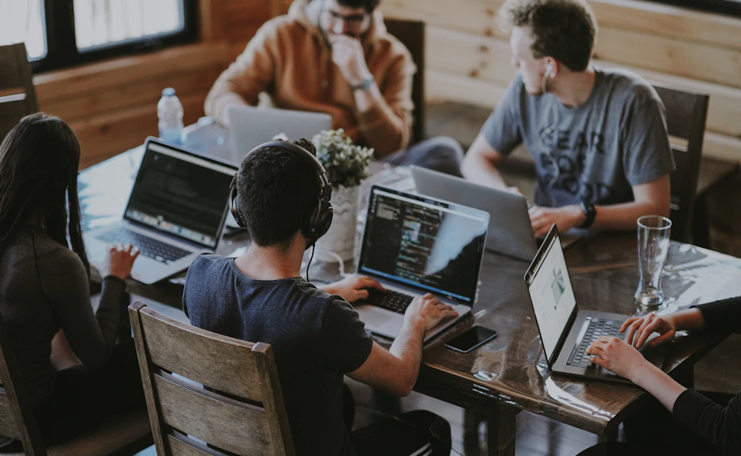 Equipo de trabajo colaborando con varios computadores.