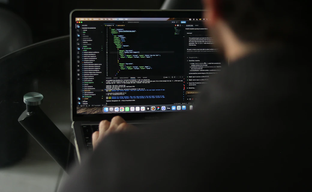 Desarrollador trabajando con código en un computador portátil.